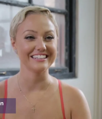 Smiling woman with short hair in a red top sits indoors, with text overlay showing her name and profession as a dancer.