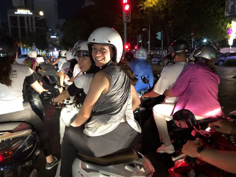 Riding double on a scooter with helmet on in Vietnam