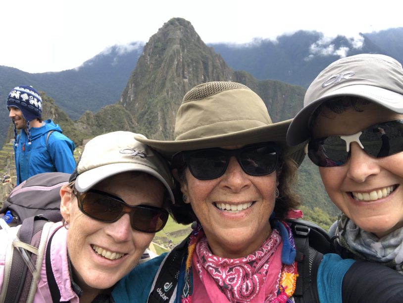 Three women in hiking hats and sun glasses at Machu Piccu