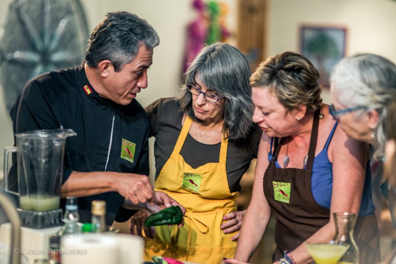 Women gathered around a chef for a Mexican cooking class