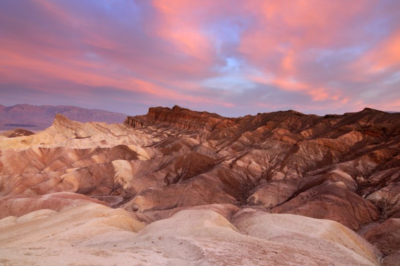 Landscape of Zabriskie point with bright pink sky, Death Valley