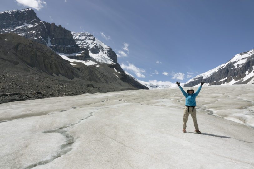 Woman explores hikes melting Athabasca Glacier Jasper National Park Alberta Canada