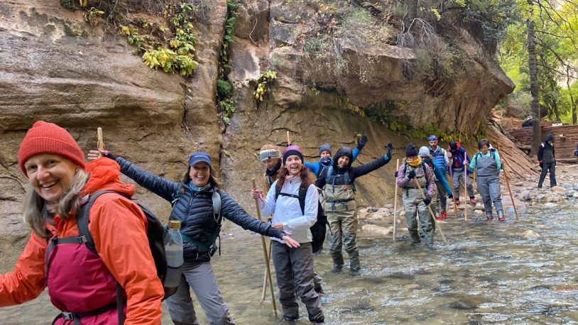 Women hiking the Narrows in Zion , ankle deep in mountain water.