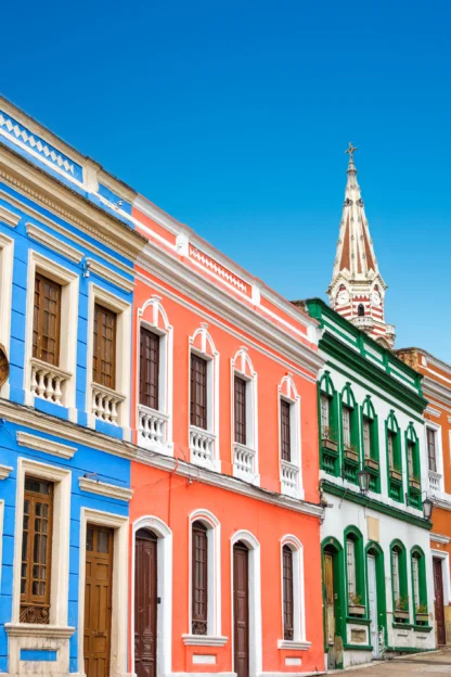 Colorful colonial-style buildings line a street with a clear blue sky above.