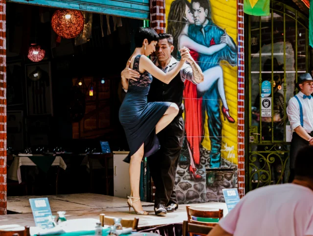 Tango dancers performing at a restaurant stage along streets of the Caminito district in Buenos Aires Argentina