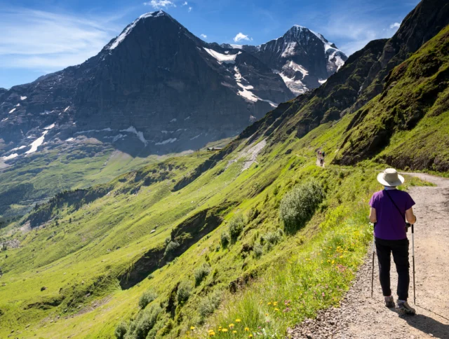 Switzerland Travel - female hiking on a trail from Mannlichen to Kleine Scheidegg of the Swiss Alps in the Jungfrau region