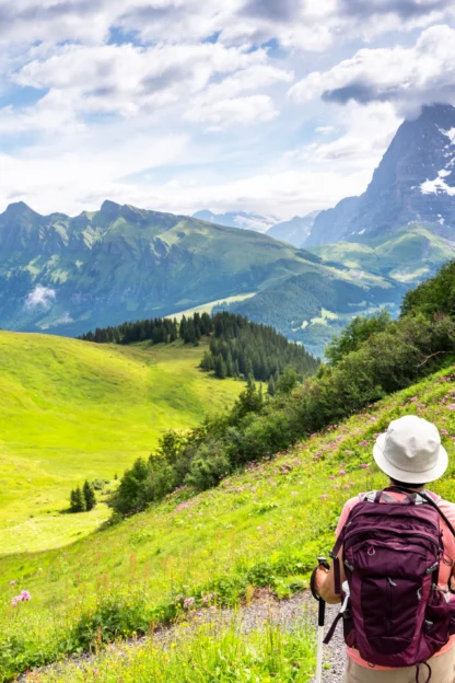 Switzerland Travel - woman hiking through the Mountain view trail in the Swiss Alps in the Jungfrau region.