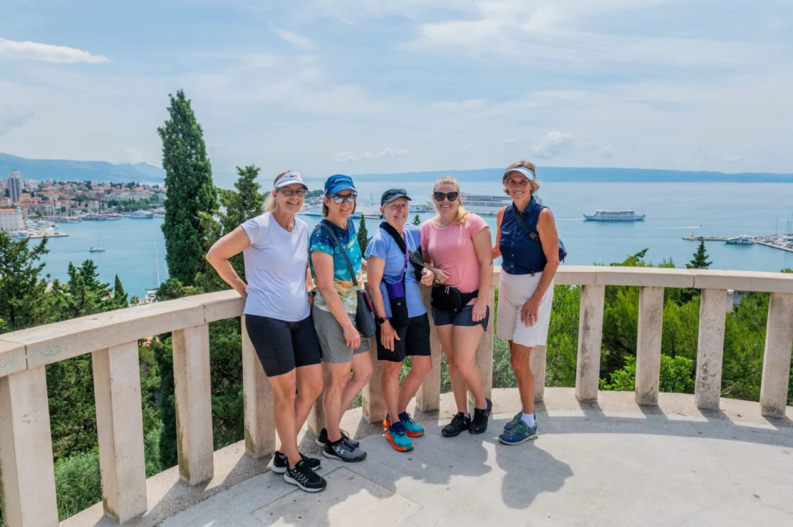 A group of women on a balcony overlooking the ocean.