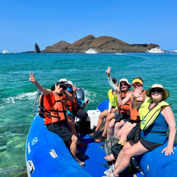 A group of women wearing life jackets, enjoying their time on a boat.