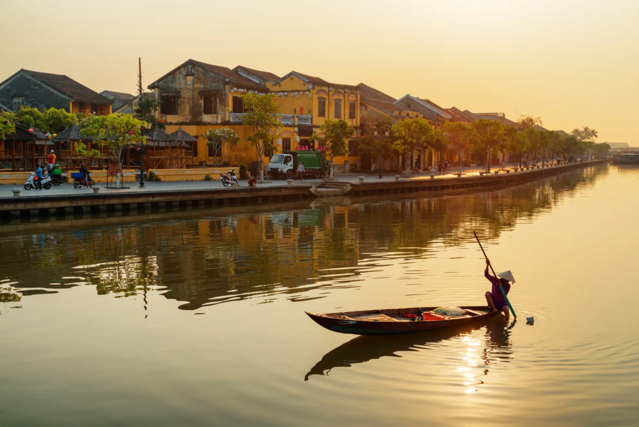 Vietnamese woman in traditional bamboo hat on wooden boat