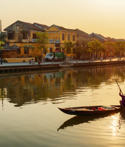 Vietnamese woman in traditional bamboo hat on wooden boat