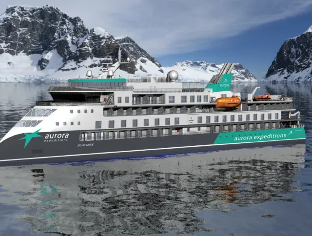 A modern expedition cruise ship with "aurora expeditions" branding sails in icy waters near snow-covered mountains and glaciers.